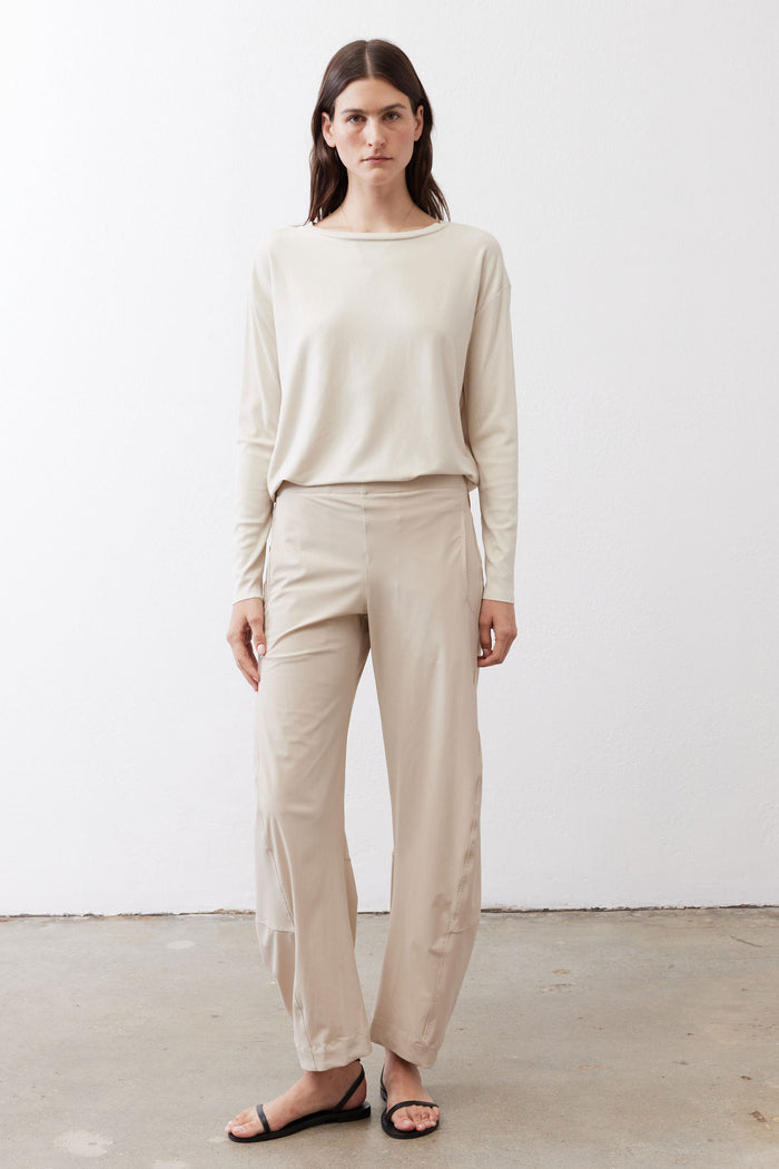 Relaxed light beige work pants with elastic waistband and ankle length; model front view.