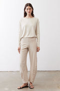 Relaxed light beige work pants with elastic waistband and ankle length; model front view.