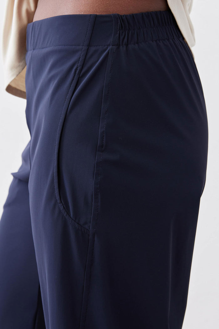 Deep navy work pants close-up: gathered waistband and front seam detail.