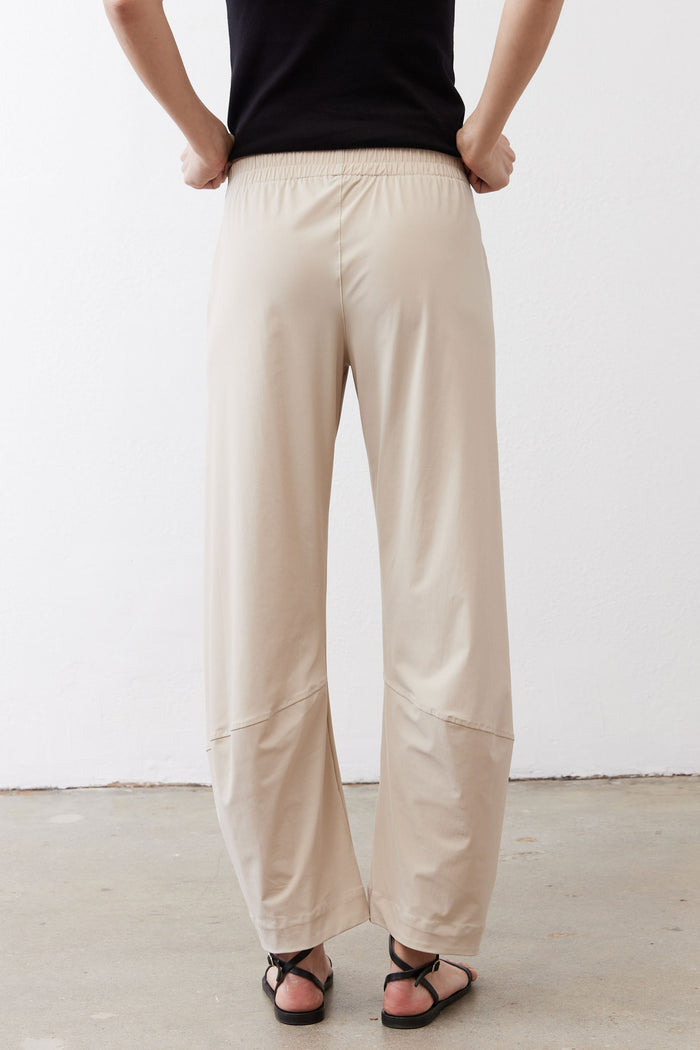 Back view of light beige elastic-waist work pants with full-length relaxed fit.