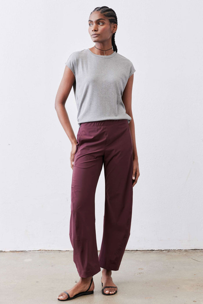 Aubergine work pants with drapey relaxed legs and elastic waistband, full-length look