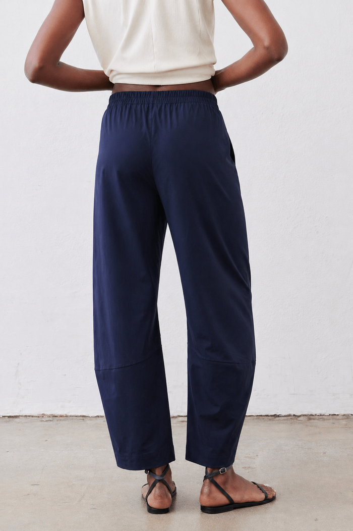Deep navy loose work pants, back view with elastic waist and wide straight legs.