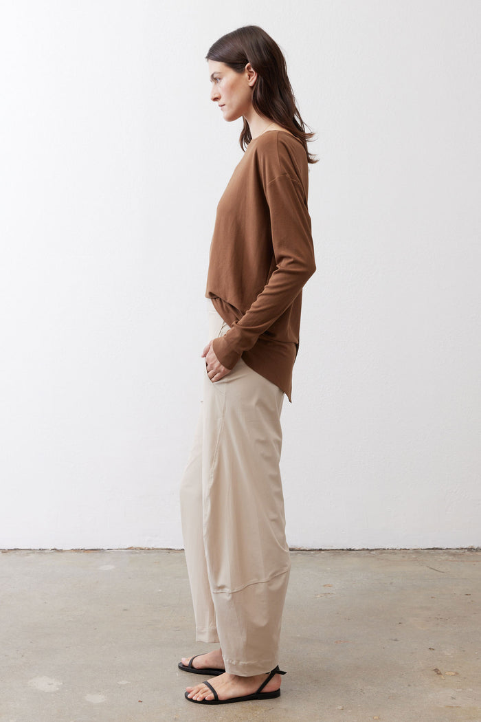 Light beige work pants with elastic waistband and relaxed straight legs; side view.