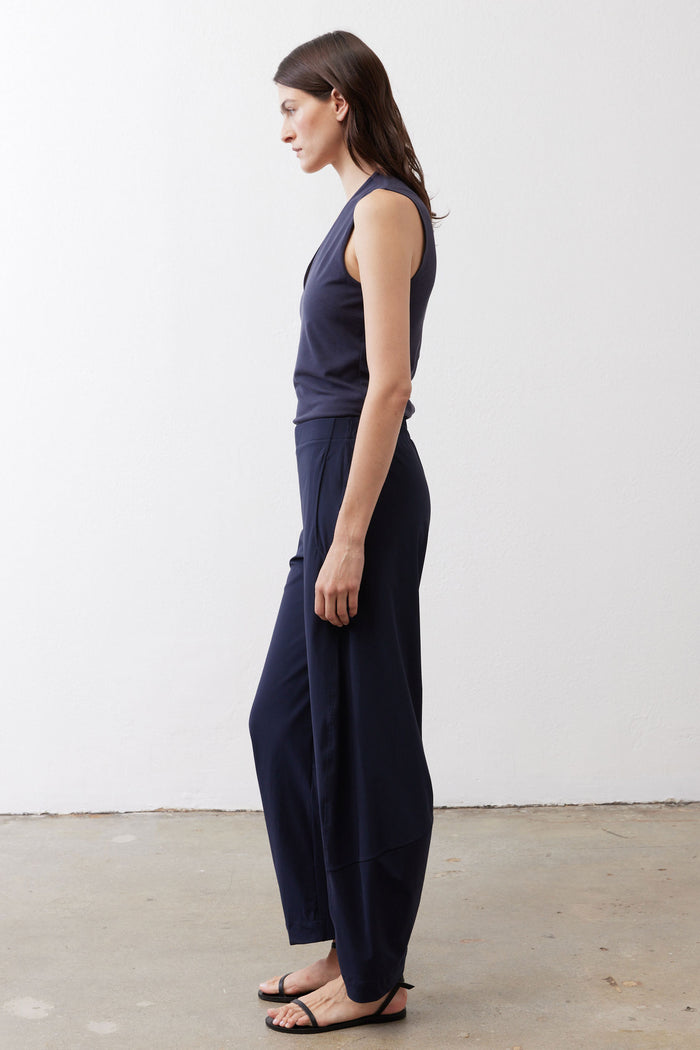 Deep navy loose work pants, side profile with relaxed wide legs and ankle hem.