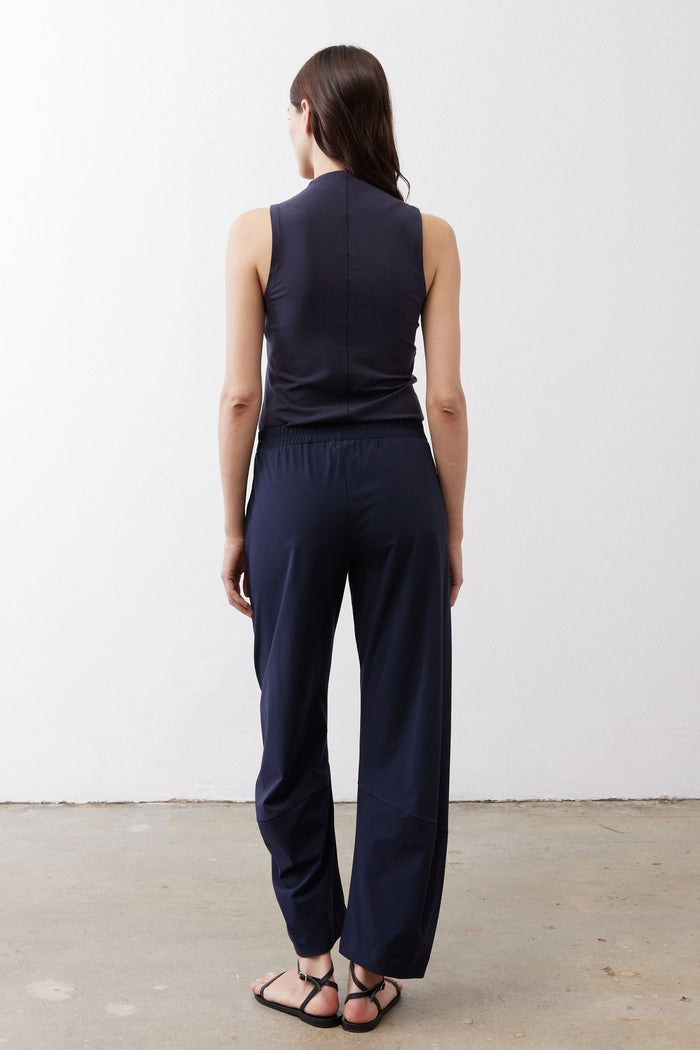 Deep navy work pants from behind, straight-leg silhouette with gathered elastic waist.