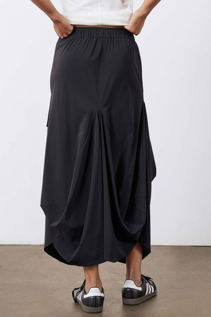 Black midi skirt with elastic waistband and flowing, layered drape at the hem