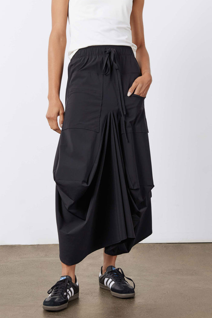 Black skirt front view: drawstring waist with tiered drape and cargo pocket styling