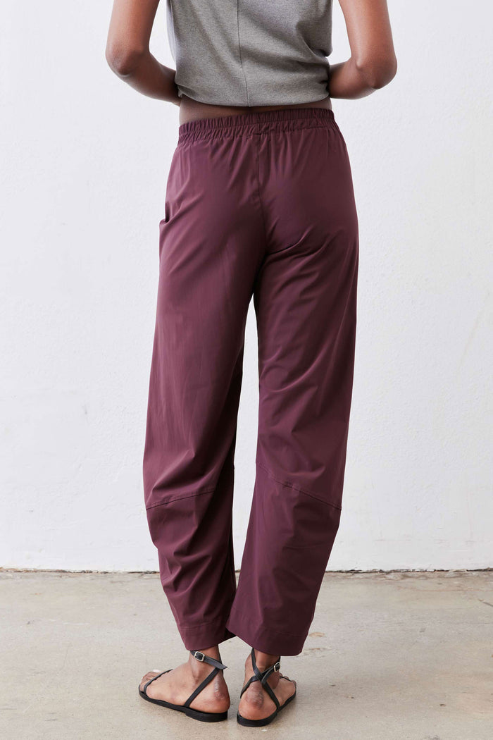 Aubergine work pants close-up: elastic waist with relaxed wide legs and ankle-length hem