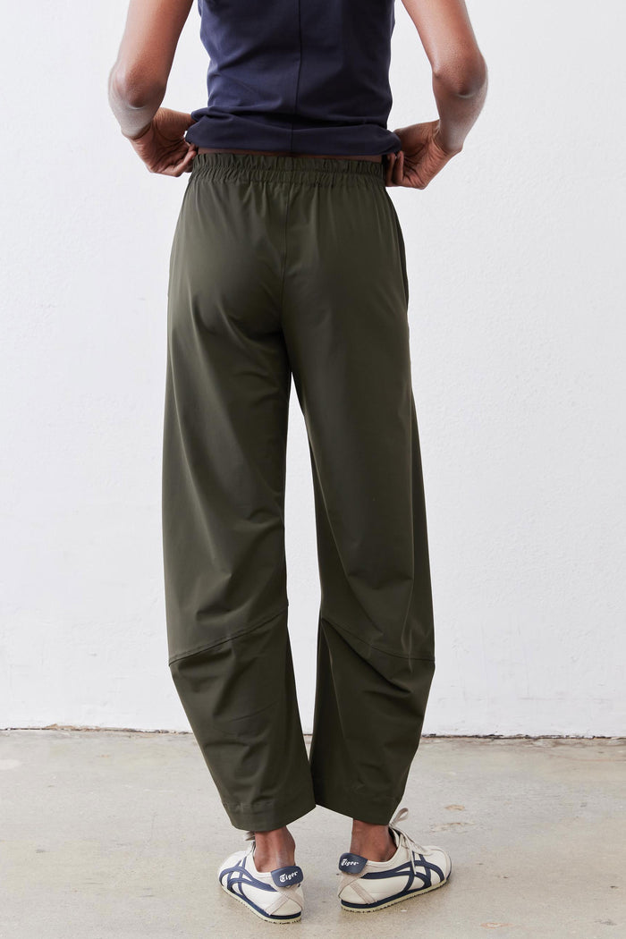 Olive green back view of loose work pants with elastic waistband and pockets