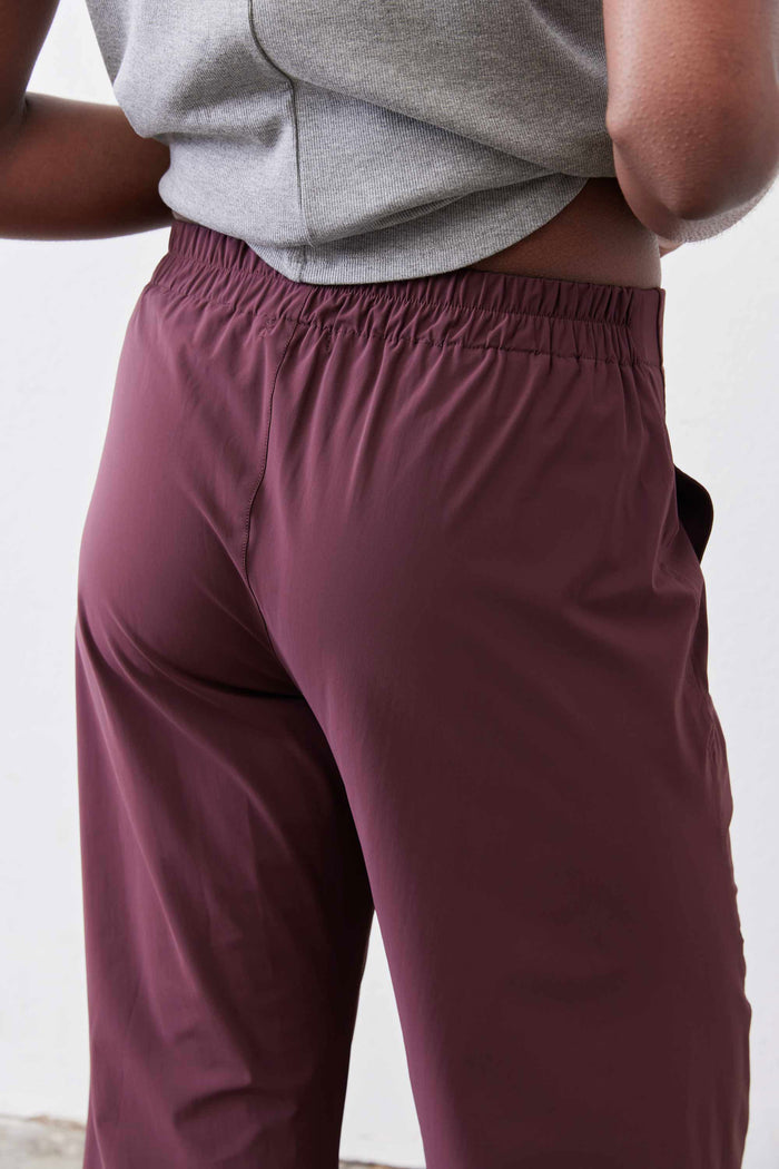 Aubergine work pants close-up: gathered elastic waistband with relaxed leg fabric