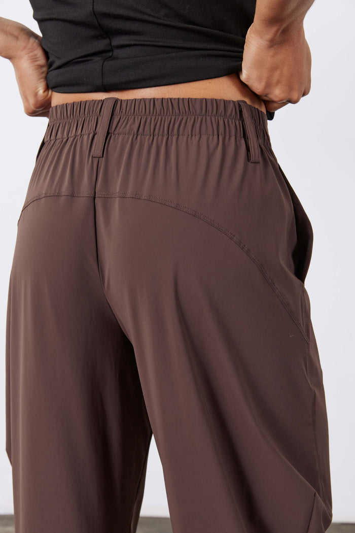 Coffee-brown pants with elastic waistband and angled seam detail at back