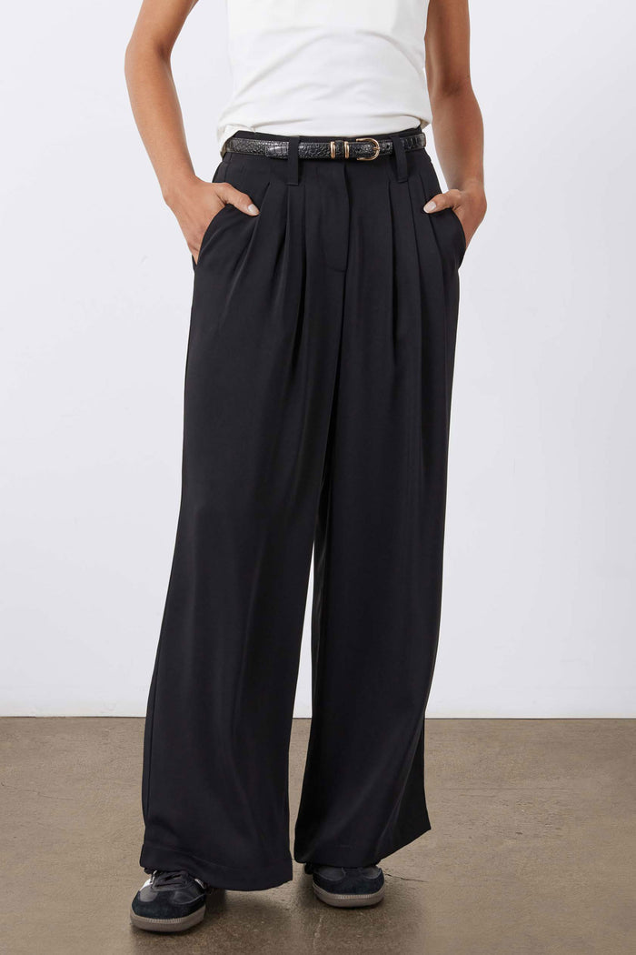 Petite black wide-leg trousers with pleated waist and flowing wide legs.