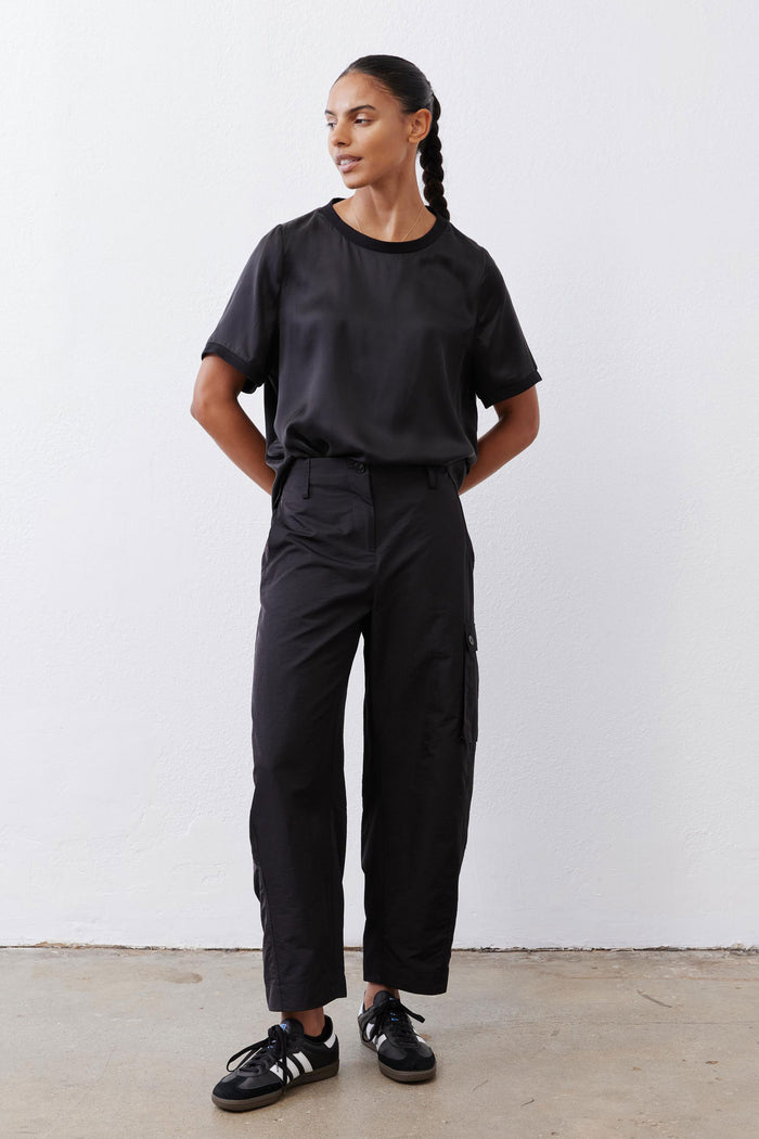 Black relaxed cargo barrel pants with cargo pockets and buttoned cuffs