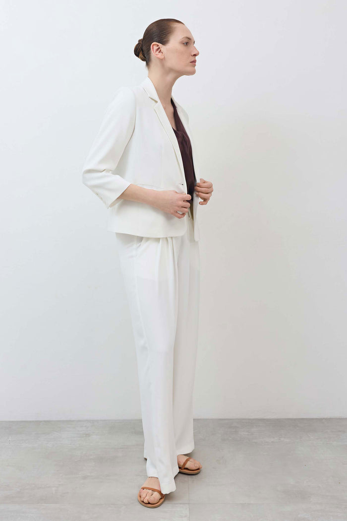 White shrunken blazer side view with notch lapel and 3/4 sleeves.