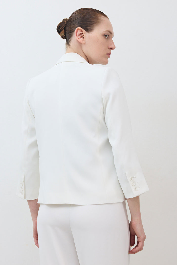 White shrunken blazer with 3/4 sleeves, cropped back view, tailored seams.