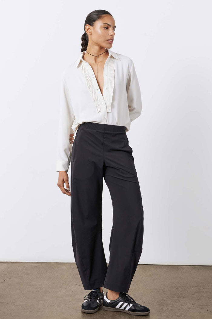 Off-white long-sleeve blouse with pointed collar and button front, pleated trim