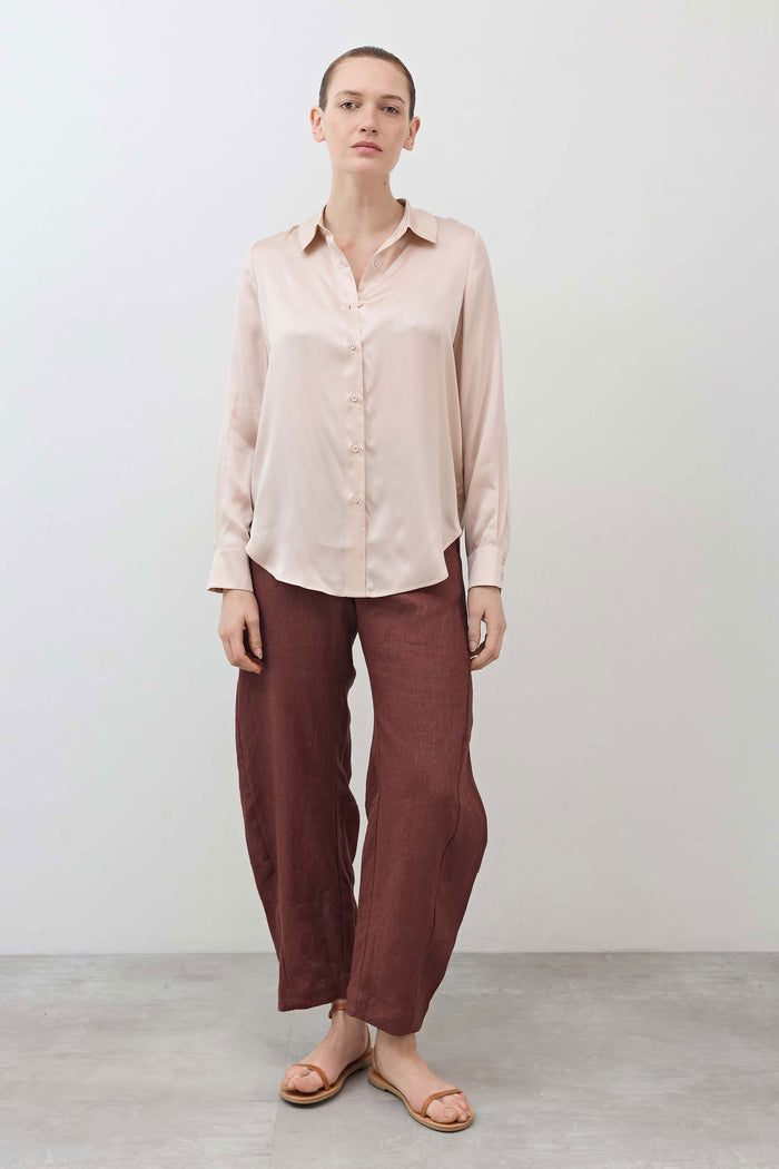 Peach blush silk button-down top with long sleeves and front button placket