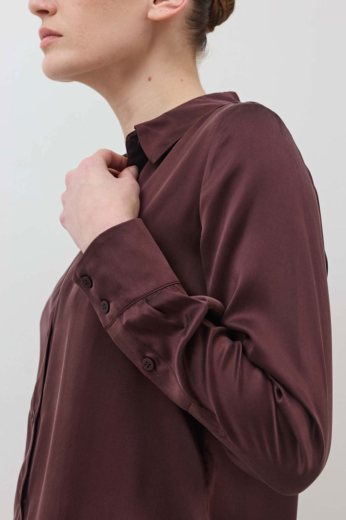 Dark plum silk button-down top with buttoned sleeve placket and cuff detail