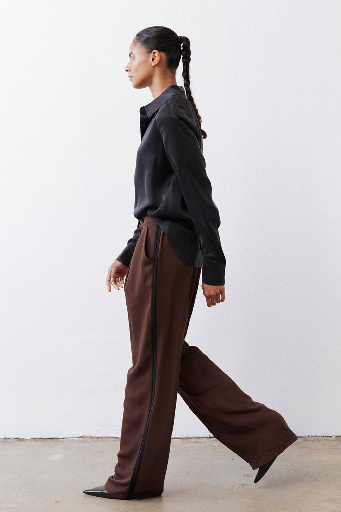 Black silk button-down top with pointed collar and button front, side view