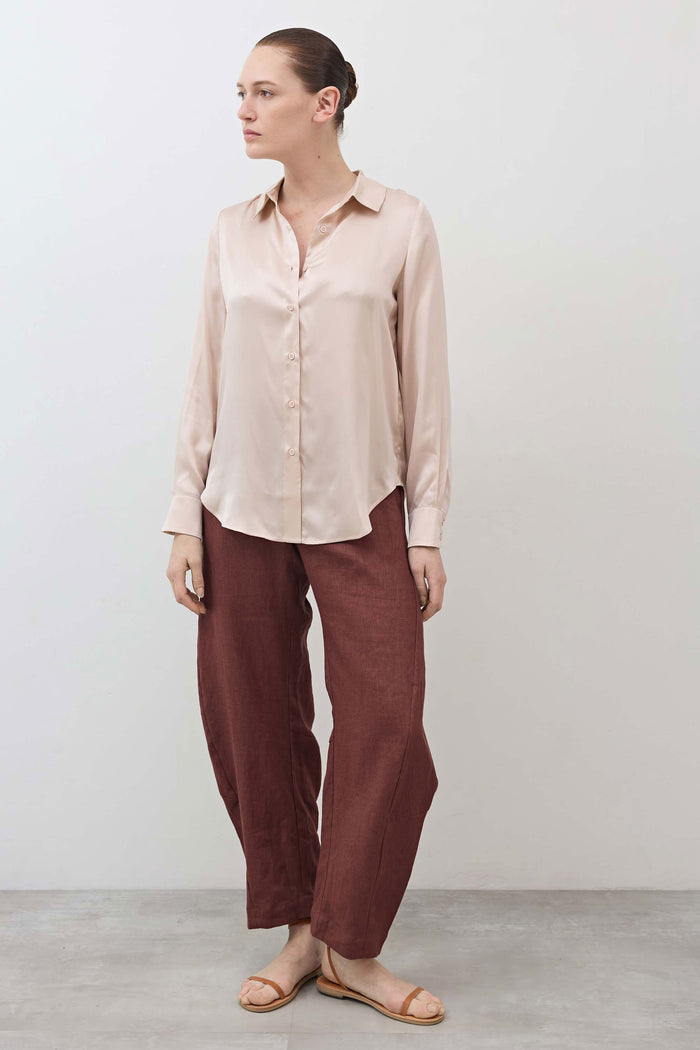 Peach blush silk button-down top with collared neckline and front buttons, side view