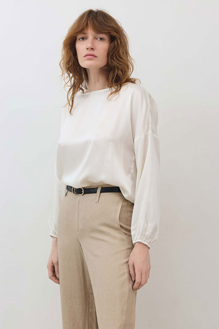 Ivory silk blouse with scoop neck, relaxed fit, long sleeves, cinched hem