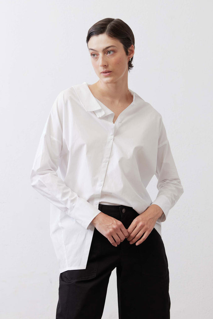 White button-down top with pointed collar and button front, worn untucked