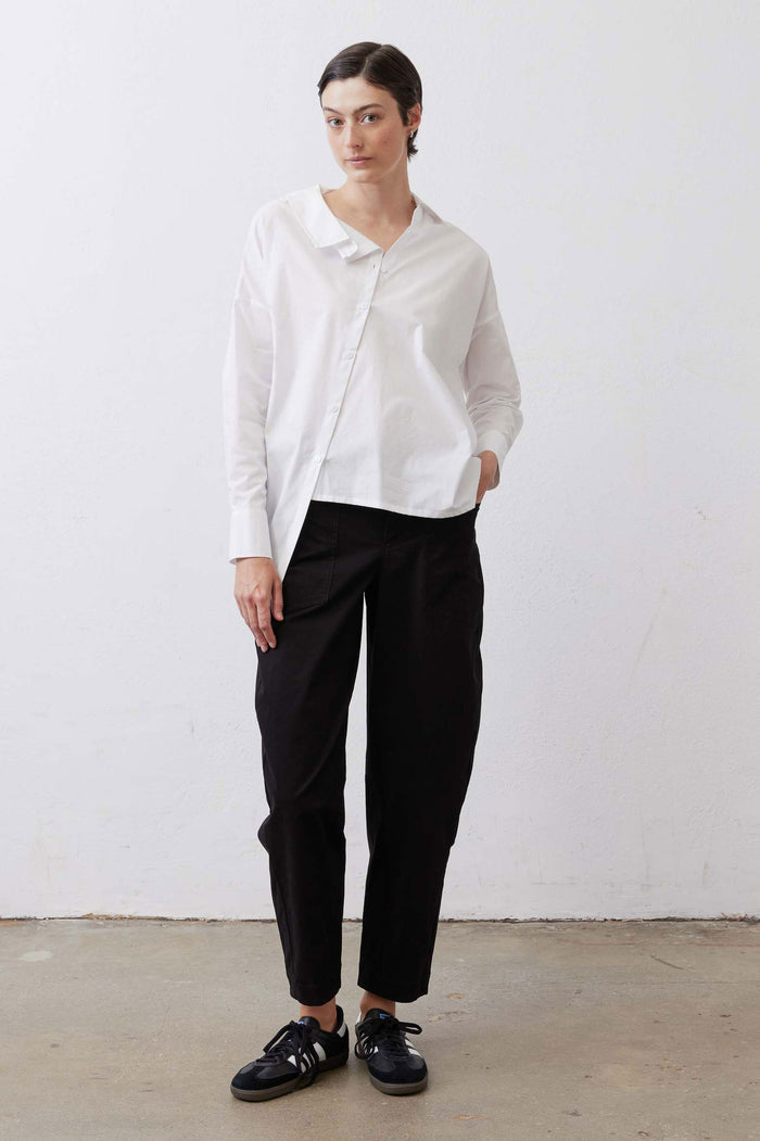 White button-down top with pointed collar and long sleeves, front tucked