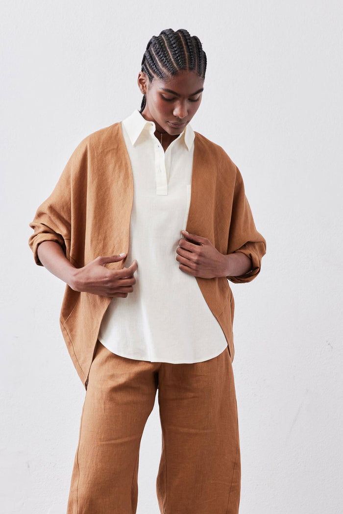 Caramel linen cardigan with open front and patch pockets, loose cocoon silhouette.