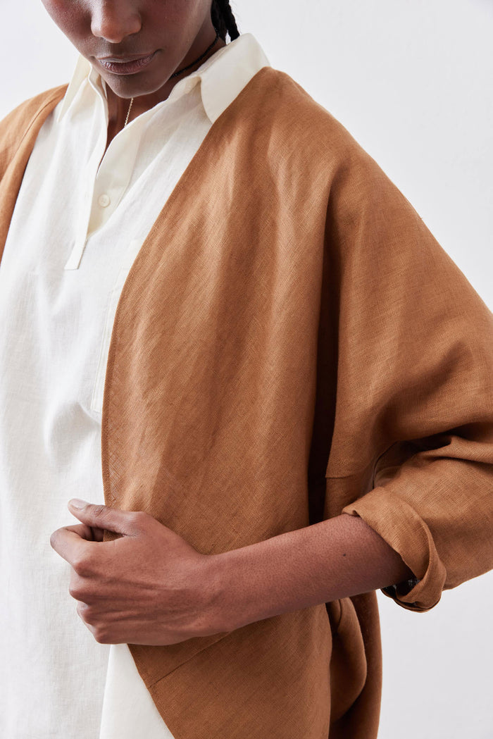 Caramel linen cardigan close-up with cuff and shoulder seam; open front.